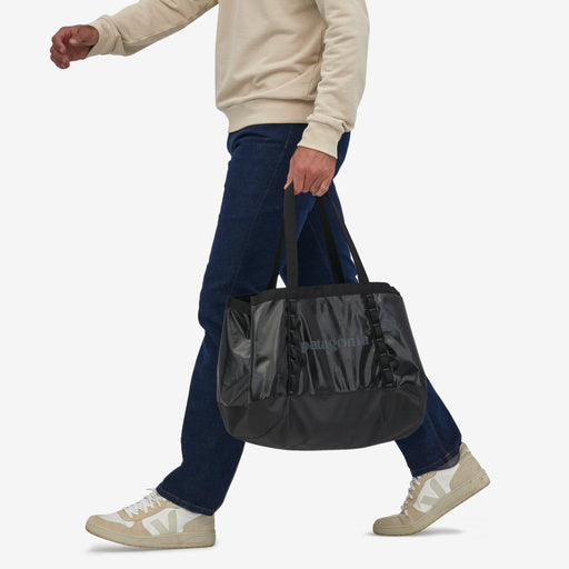 Patagonia Black Hole Tote 25L, black, hand held by model view.