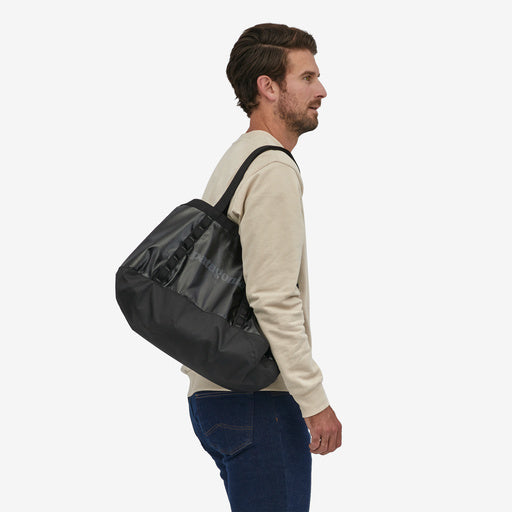 Patagonia Black Hole Tote 25L, black, shoulder held by model view.
