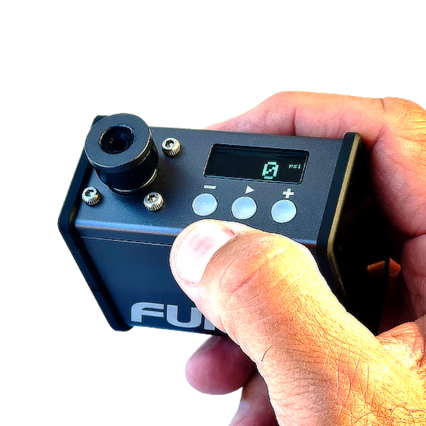 Hand holding a small electronic device with a digital display and control buttons, branded 'Ful'.
