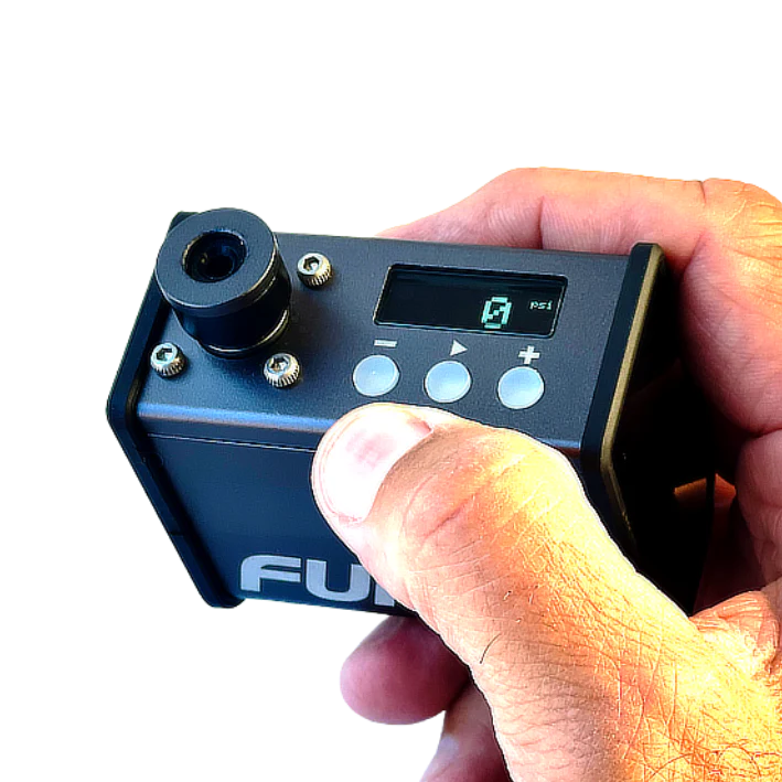 Hand holding a small electronic device with a digital display and control buttons, branded 'Ful'.