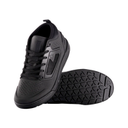 Black athletic shoe with textured sole on a white background