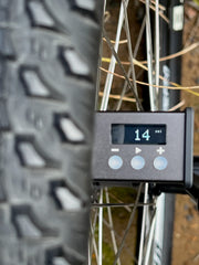 Close-up of a tire with a digital display showing pressure on a vehicle.