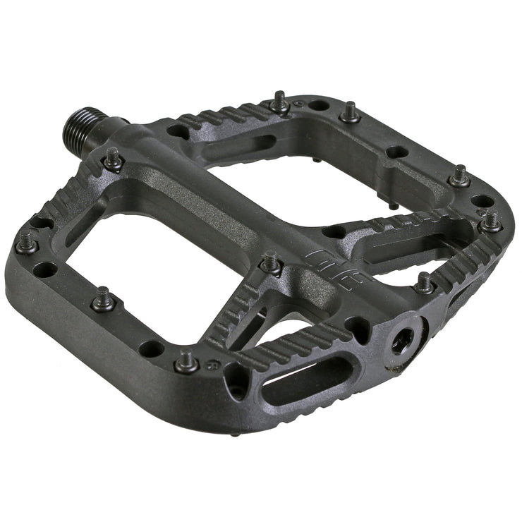 A black OneUp Components Comp Platform Pedal designed for mountain bikes, featuring multiple steel pins for traction and a wide stable platform.