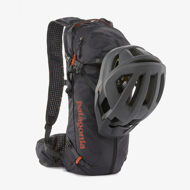 Patagonia Dirt Roamer Mountain Biking Pack, Ink Black, backpack with helmet secured on the front of the back pack view