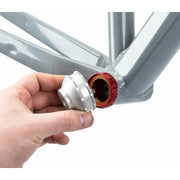 Park Tool BBT-79.3 Bottom Bracket Tool - 12-Notch, Silver. Model placing tool on bottom bracket of a bike view.